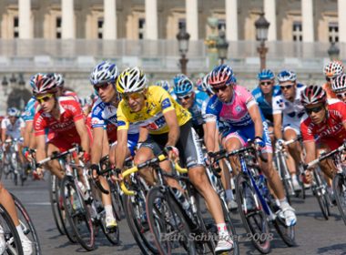 Carlos Sastre racing in yellow on the Champs Elysee